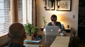 A teenager at a table with a laptop.