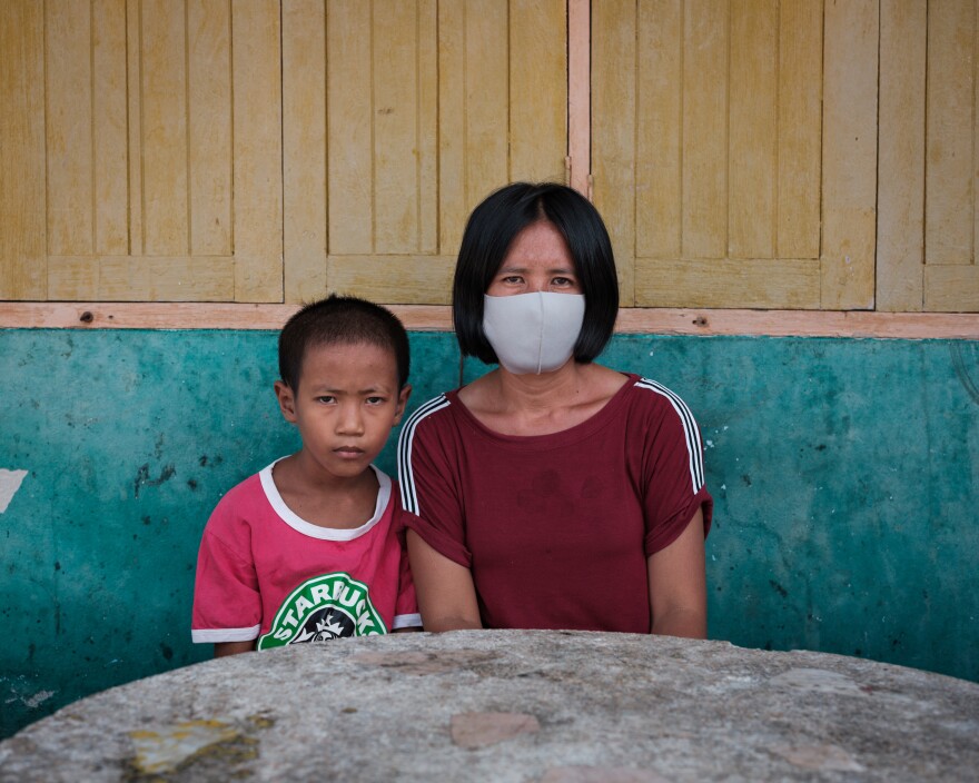 Pranee Thermuangpak, 38, with one of her three children. Pranee's husband, Samart Thermuangpak, a construction worker, tried to kill himself after his application for the 5,000 baht in government aid was denied. Pranee is epileptic and unable to work; her mother needs regular medication.