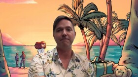 Man wearing a Hawaiian shirt with a graphic of the beach and people on it behind him 