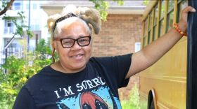 Charlotte artist Michelle "Bunny" Gregory stands next to the bus she's converting into a mobile studio that will travel around the city to help kids in undeserved communities learn creative skills, including art activities and music.