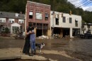 Resident Anne Schneider, right, hugs her friend Eddy Sampson as they survey damage caused by Hurricane Helene, Oct. 1, 2024, in Marshall, N.C.
