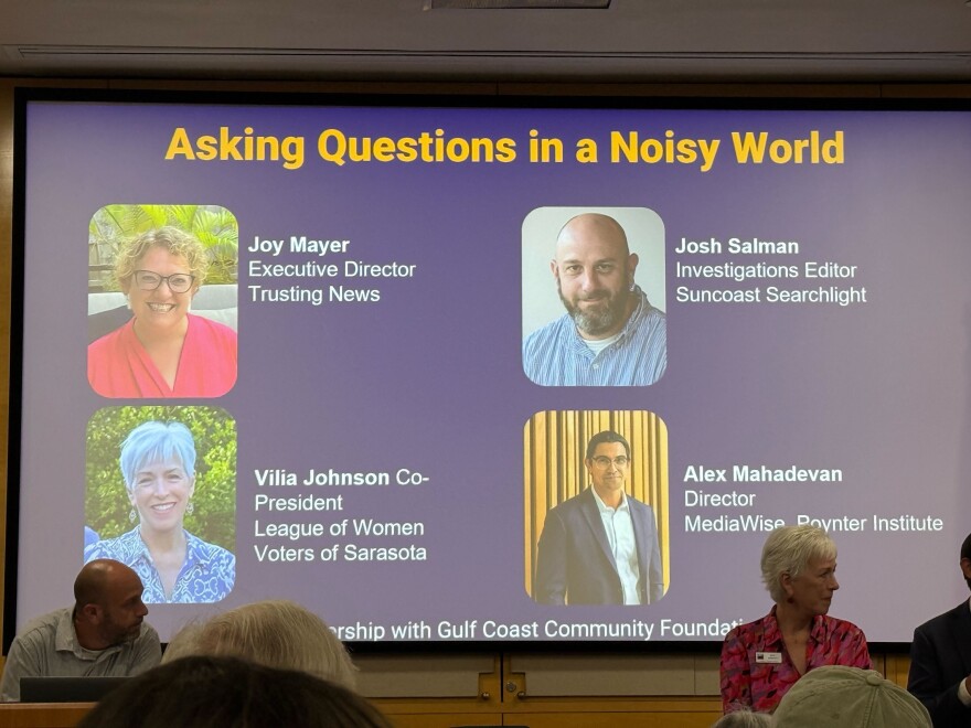 A  slide image projected on a screen with 4 photos of the speakers on the panel 