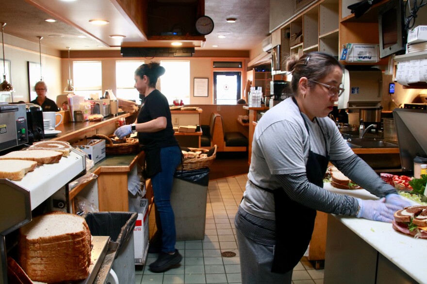 Two employees at Perry's Restaurant make lunches behind the counter.