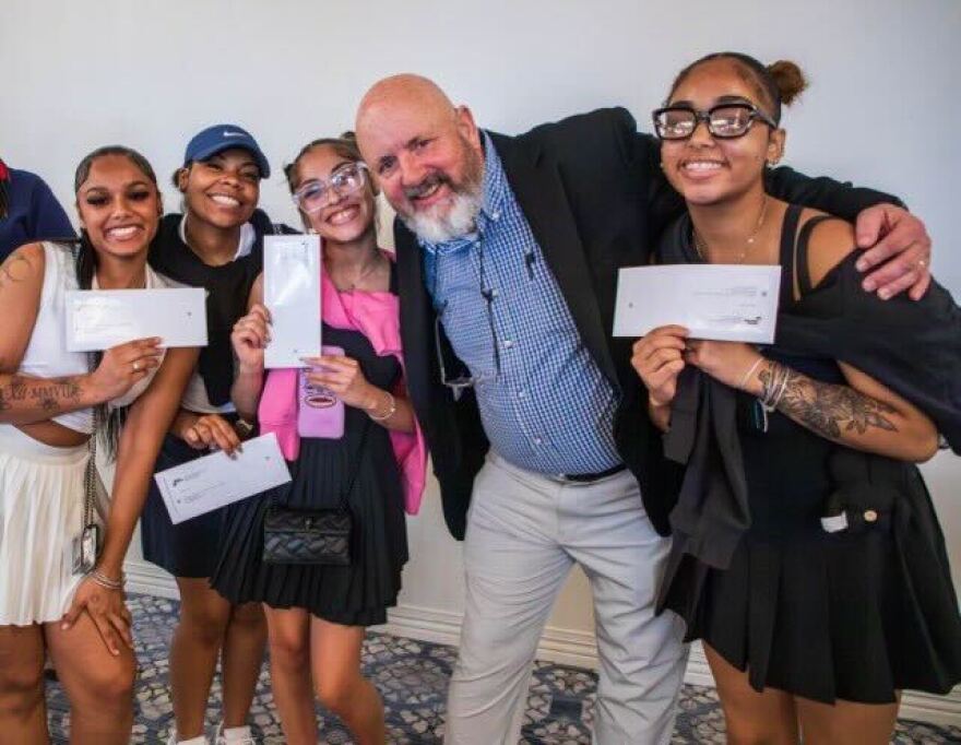 CMSD alum Mark Stepowoy, middle, celebrates with 2026 graduates on Friday, May 22 after gifting each graduating senior with a $500 check.