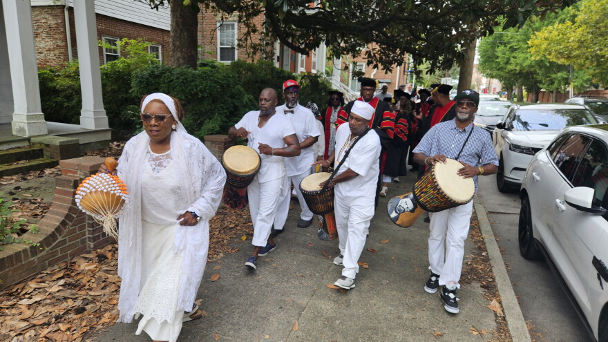 Nana Mayla leads a procession to Long Warf in Cambridge