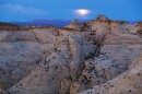Scenic desert mesas under a dark blue sky.