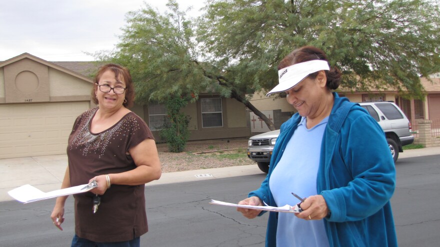 Democratic organizers Rebecca Larios (left) and Norma Muñoz canvass a South Phoenix neighborhood ahead of President Obama's visit.