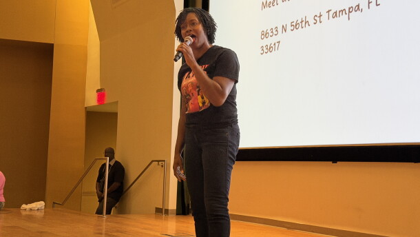Woman speaking into a microphone on stage