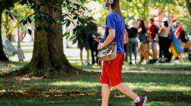 In this file photo, a masked student walks on the Illinois State University campus.