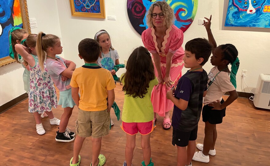 Wendy Rodrigue leading a group of students on a tour of an exhibit of artwork by her late husband, George Rodrigue