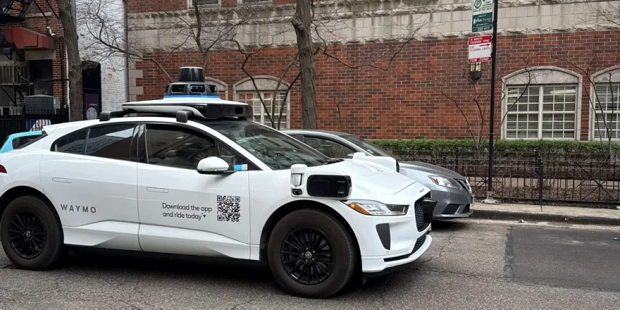 A Google-operated Waymo vehicle drives through Chicago’s Near North Side, with a driver, as the company begins testing and mapping the city in March 2026.