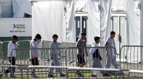 FILE - In this Feb.19, 2019 file photo, children line up to enter a tent at the Homestead Temporary Shelter for Unaccompanied Children in Homestead, Fla. The Biden administration plans to partially end the 27-year-old court supervision of how the federal government cares for child migrants, shortly after producing its own list of safeguards against mistreatment. (AP Photo/Wilfredo Lee, File)