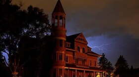 Mansion with a conical tower against a stormy night sky