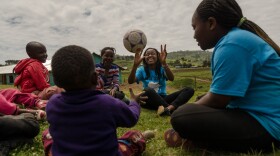 Sally Gacheru, center, tosses a ball to a child in Sakutiek, Kenya. Gacheru, who was born in Kenya but moved to St. Louis four years ago, was part of a service trip back home for fellow immigrant teens this month.