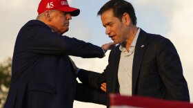 Former President Donald Trump pats Sen. Marco Rubio, R-Fla., on the shoulder at a campaign rally at the Miami-Dade County Fair and Exposition on Sunday, Nov. 6, 2022, in Miami.