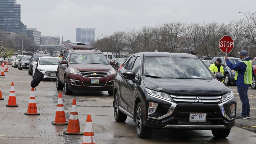 Cars line up to receive food at the Greater Cleveland Food Bank food distribution, Thursday, May 14, 2020, in Cleveland.