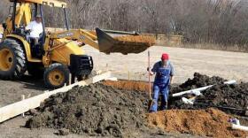 An example of the dangers of “trench digging” illustrates how workers should not stand near or under operating machinery.