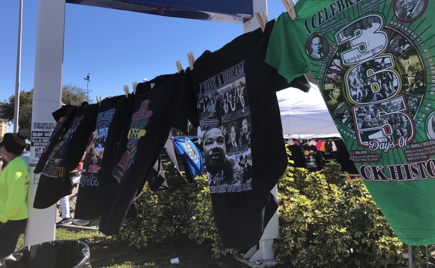 Black history t-shirts wave in the breeze along the parade route for the MLK Day parade in Liberty City.