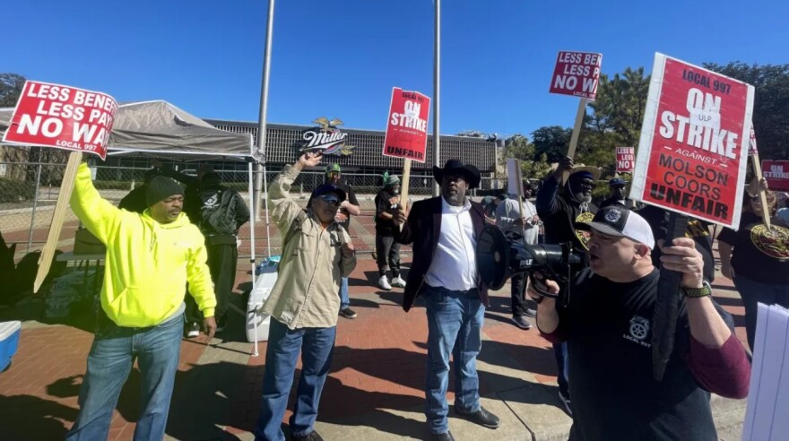 Workers at the Molson Coors brewery in south Fort Worth are seen in front of the facility holding strike signs.