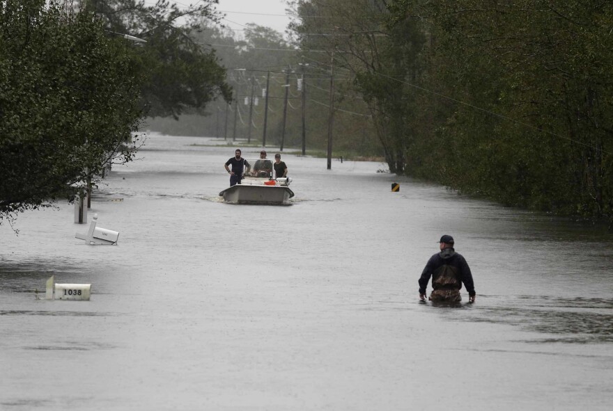 A member of the U.S. Coast Guard walks down Mill Creek Road Saturday checking houses after Florence hit Newport, N.C.