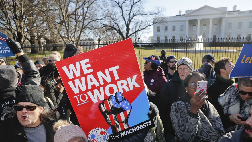 Union members and other federal employees protest in front of the White House on Thursday. Many are out of work as the partial government shutdown has dragged on longer than any in history.