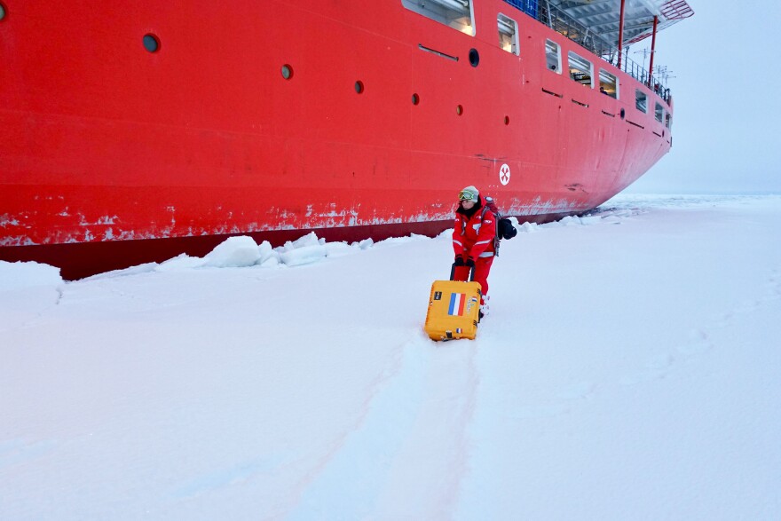 Scientist Jessie Creamean moves a portable aerosol sampler out onto the ice to test it in the cold conditions.