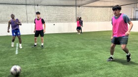 Players are playing five on five soccer on a turf soccer field 