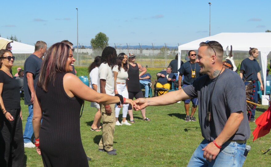 People laughing and holding hands in crowd. 