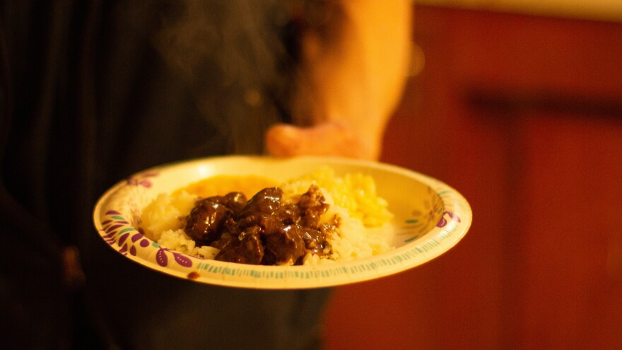 Melovidov holds a plate of fur seal and rice.