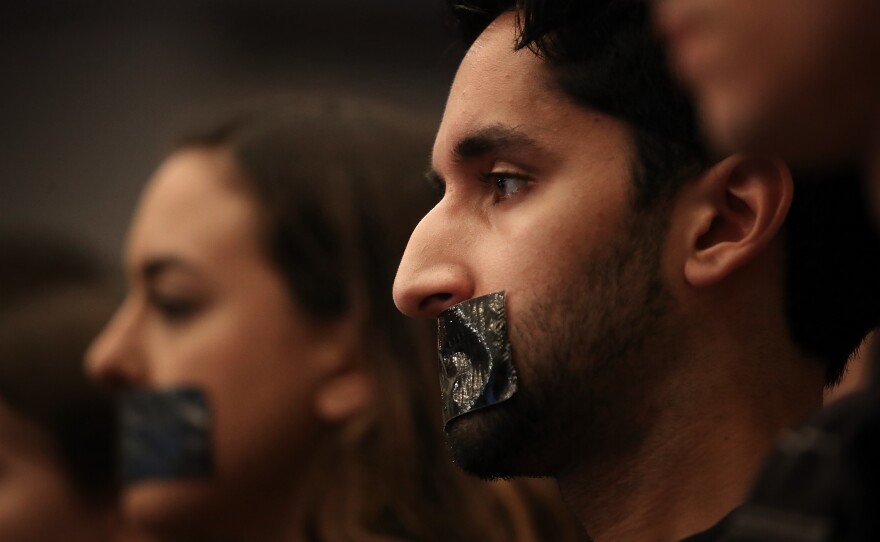 Georgetown University Law School students cover their mouths with tape to protest Sessions' speech on Tuesday.
