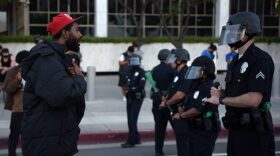A man reacts in front of a row of police officers as protesters gather in downtown Los Angeles to demonstrate after George Floyd, an unarmed black man, died while being arrested by a police officer in Minneapolis who pinned him to the ground with his knee.