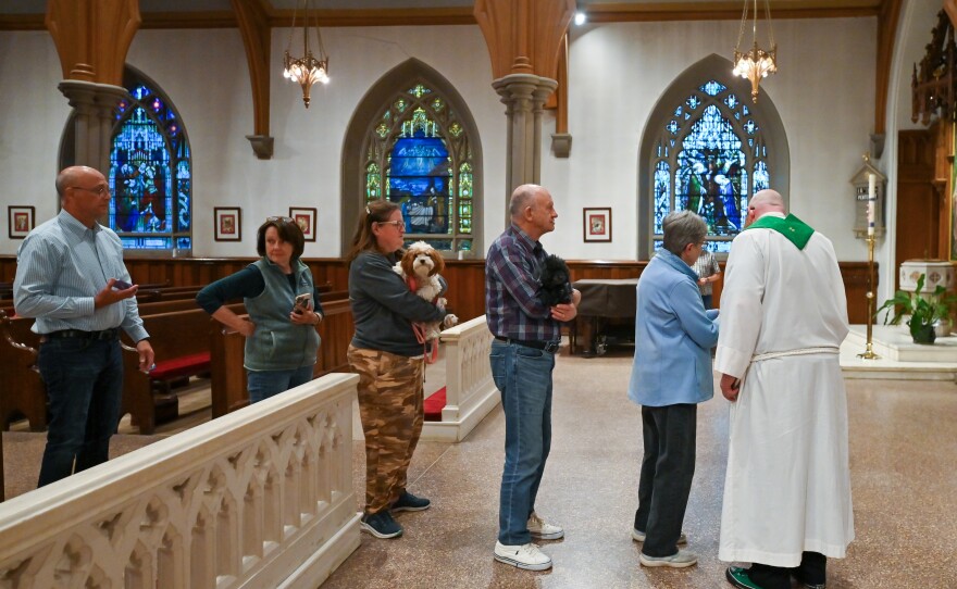 Parishioners line up with their four-legged friends and photos of their pets at a special service at St. Luke's Episcopal Church that celebrated the Feast Day of St. Francis of Assisi.
