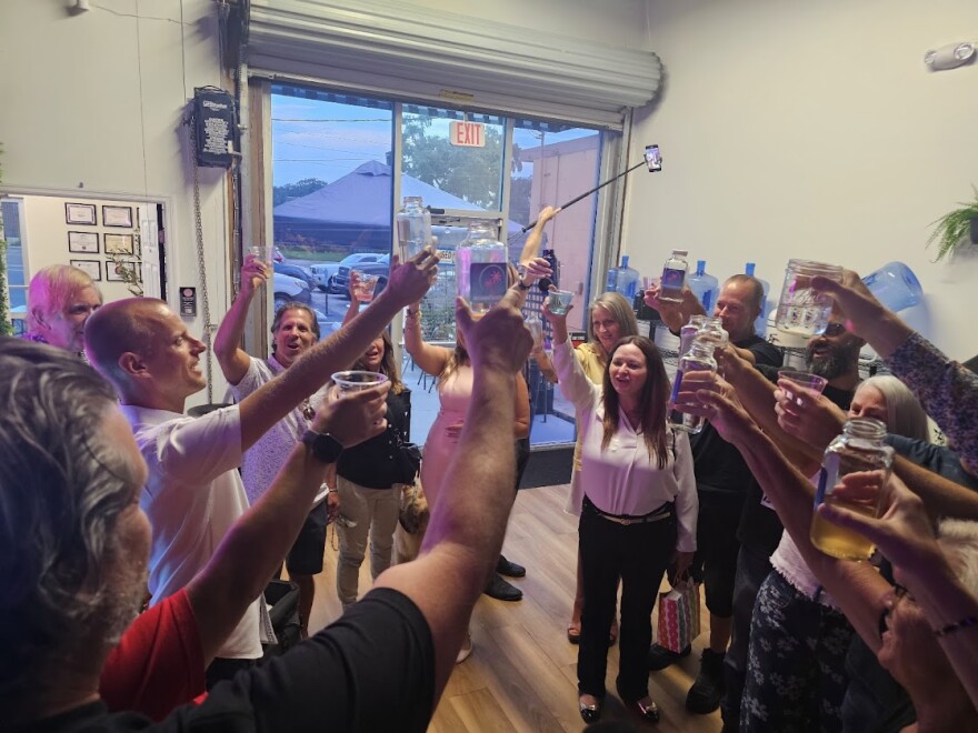 Orange County resident and anti-fluoride activist Justin Harvey (left, middle) leads his fellow activists in a toast using fluoride-free water, celebrating SB 700 going into effect on July 1, at the Florida Water Bar/Refill Station. The law, signed by Gov. Ron DeSantis, prevents water treatment facilities from adding water quality additives, like fluoride, to community water.