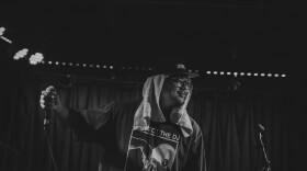 Ryan Cordero performs on stage with a microphone in hand