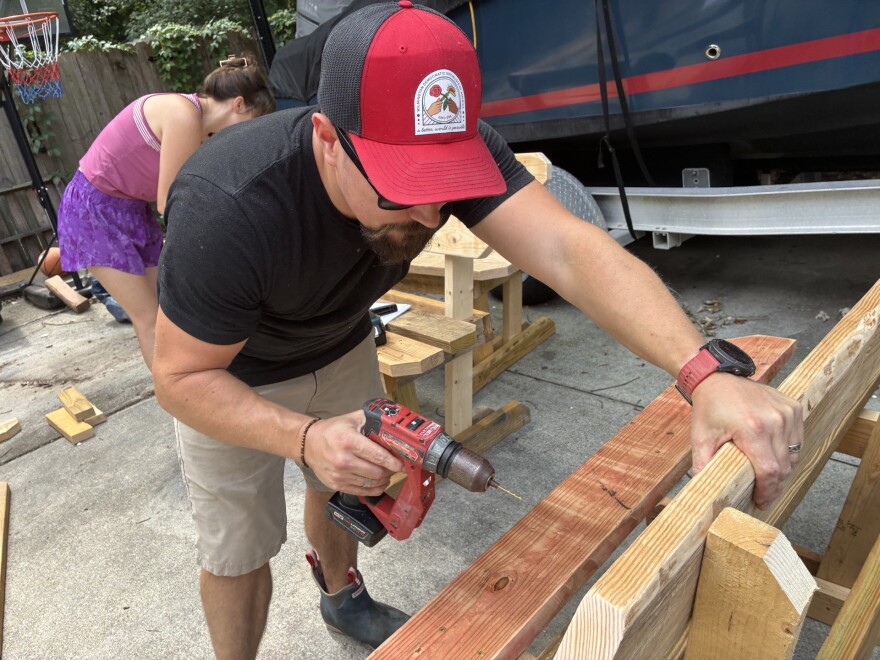 Adrian Girth works on a bench to post near a Wave bus stop. The benches will get a paint job before being placed. He says the DSA maintains and monitors the benches they've put out, though they don't have permits to place them.