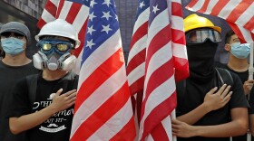 Pro-democracy students hold U.S. flags and sing the Star-Spangled Banner at the University of Hong Kong, Friday, Sept. 20, 2019, as they demand the U.S. Congress to pass the proposed U.S. Act of the Hong Kong Human Rights and Democracy.
