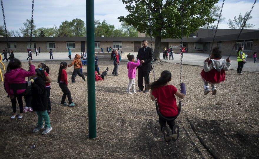 Mel Atkins (center) talks with a Buchanan Elementary School student during recess.