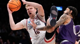 Northwestern guard Boo Buie (0) fouls UConn guard Cam Spencer (12) during the second half of a second-round college basketball game in the NCAA Tournament, Sunday, March 24, 2024, in New York. UConn won 75-58.