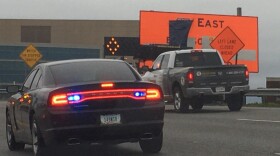 Workers uncover signs along Interstate 70 Monday morning.