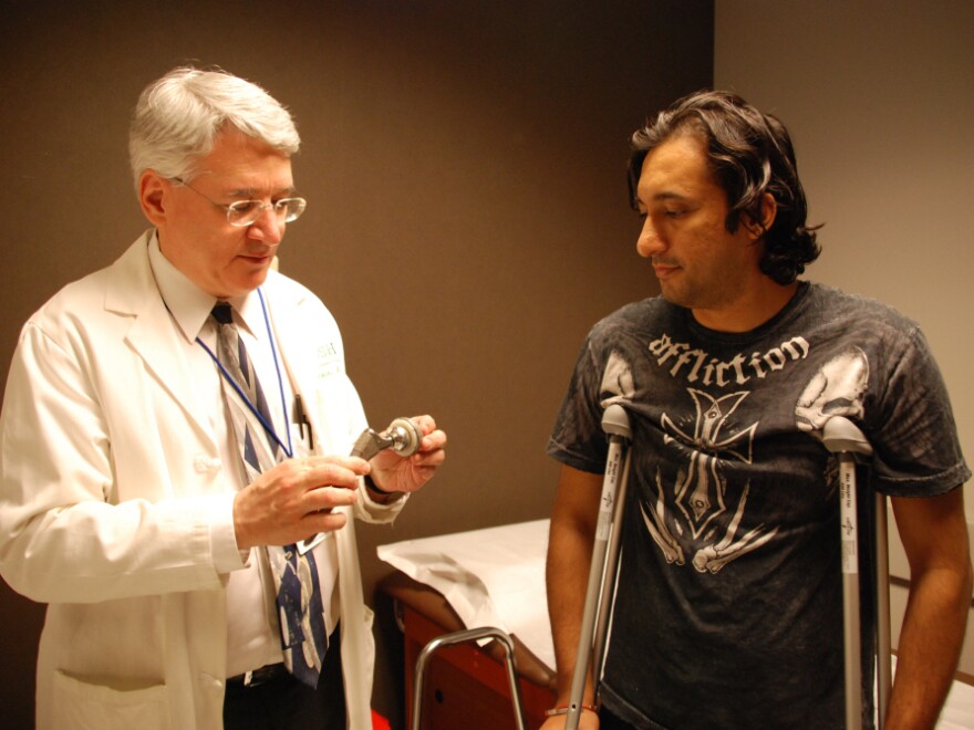Orthopedic surgeon Joshua Jacobs examines patient Ali Hussein who recently received an artificial hip with a plastic lining between a metal ball and socket.
