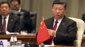 China's President Xi Jinping takes his seat for the first closed session of the BRICS summit, in Johannesburg, South Africa, Thursday, July 26, 2018. The five leaders of the BRICS emerging economies have gathered in South Africa for an annual summit where the United States is being criticized for escalating tariffs on foreign goods. (Mike Hutchings/Pool Photo via AP)