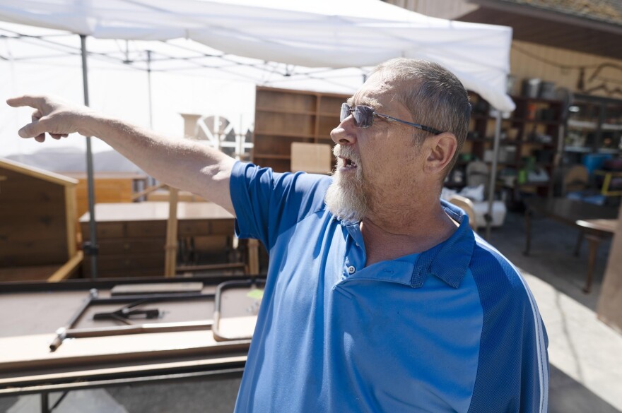 A man wearing a blue shirt points to the side