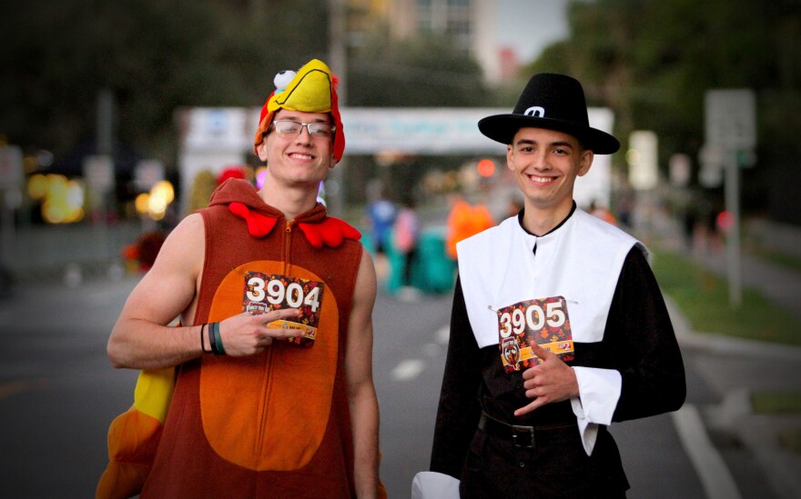 During Track Shack's Seniors First Turkey Trot 5K fun run, two men arrive at the starting line in Thanksgiving attire. The fun run also features a costume contest.