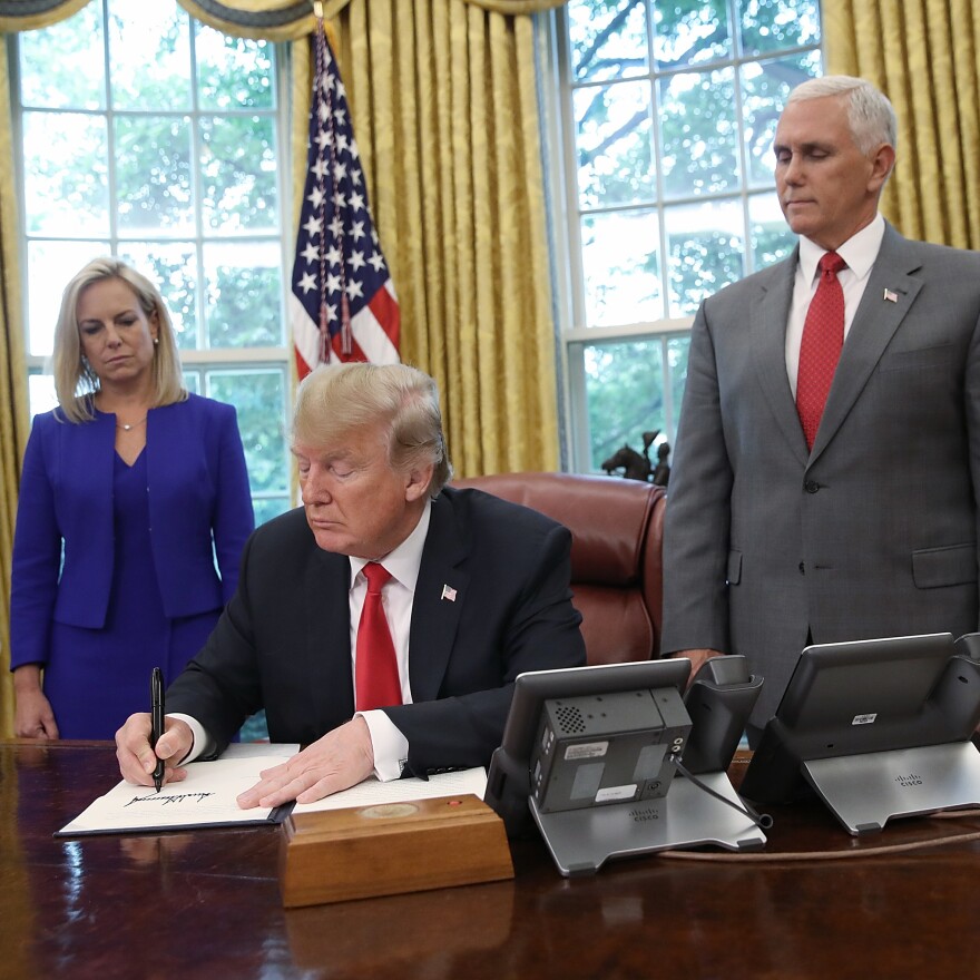 President Trump, accompanied by Department of Homeland Security Secretary Kirstjen Nielsen and Vice President Pence, signs an executive order regarding detaining migrant families on Wednesday at the White House.