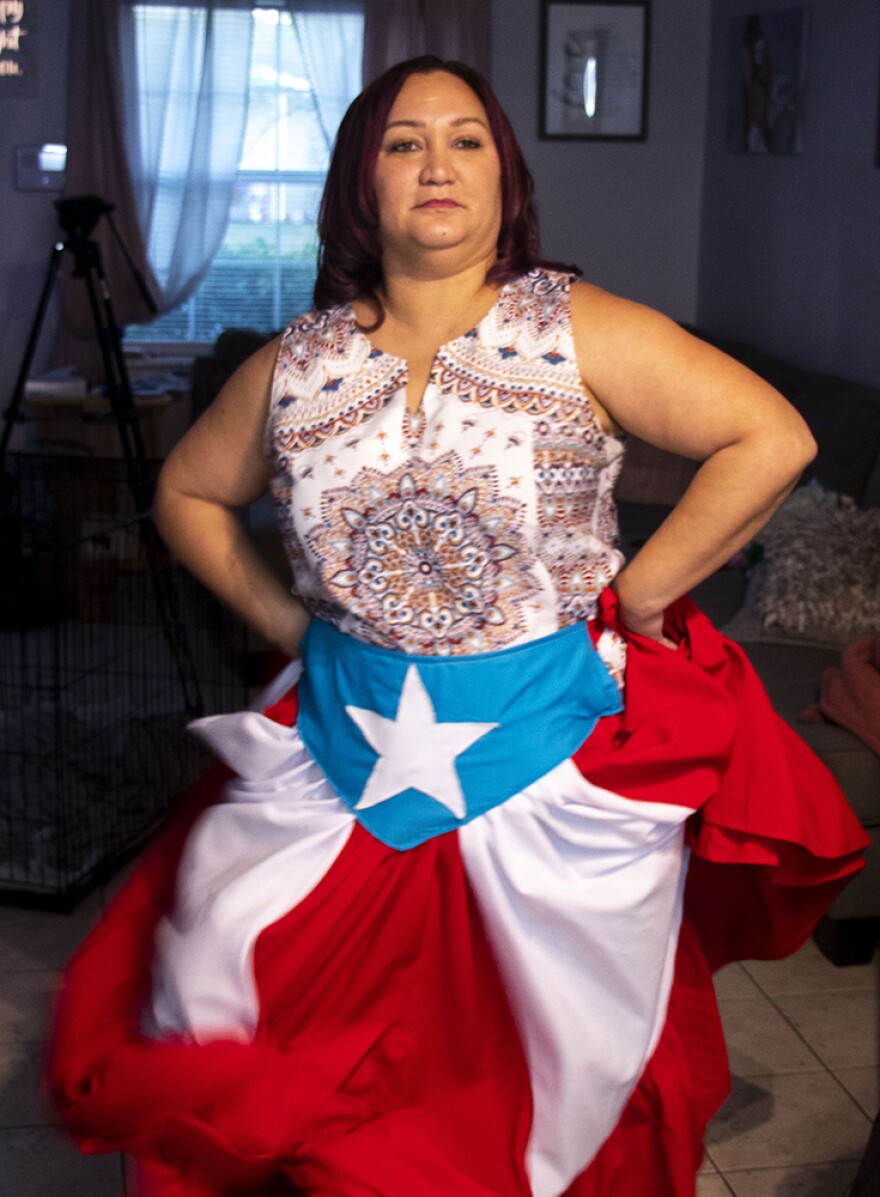 Barbara Liz-Cepeda wears a custom-tailored skirt with the Puerto Rican flag on it while she dances to the beat of the Bomba drums in her living room in Kissimmee, Fl.