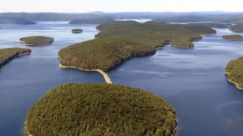 In this September 2013 aerial file photo provided by the Massachusetts Deptartment of Conservation and Recreation, a dirt and stone road leads to Mount Zion Island, at rear, at the Quabbin Reservoir in Petersham, Mass.