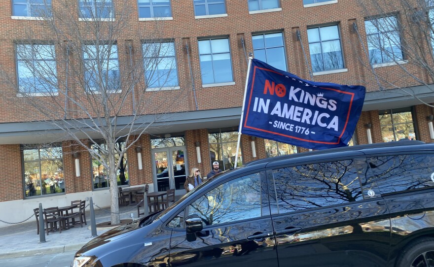 A car holding a flag drives through the Mark R. Peterson Plaza in Normal.