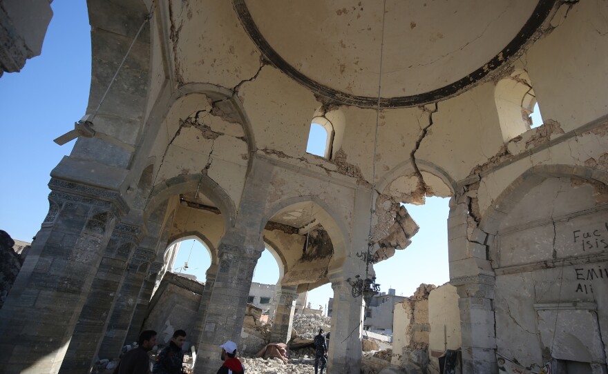 Iraqi forces and civilians stand inside the al-Nuri mosque in the Old City of Mosul in January 2018, six months after troops took back the city from ISIS.
