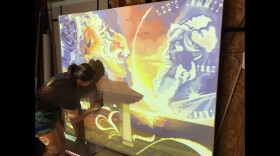 Artist Savannah Meyer transferring her digital sketch onto the final canvas for a mural at Hawthorne Bank in New Longview, Missouri.