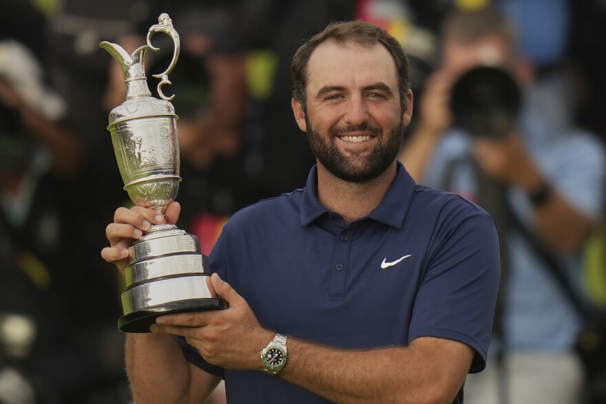 Scottie Scheffler of the United States poses for photographers with the Claret Jug trophy after winning the British Open golf championship at the Royal Portrush Golf Club, Northern Ireland, Sunday, July 20, 2025. (AP Photo/Francisco Seco)
